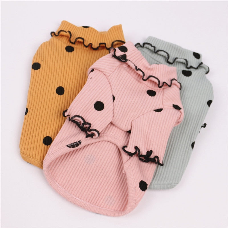 Polka dot turtleneck dog shirts in yellow, pink and green, laid flat